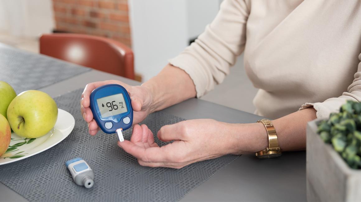 Kobieta sprawdza swój poziom cukru glukometrem