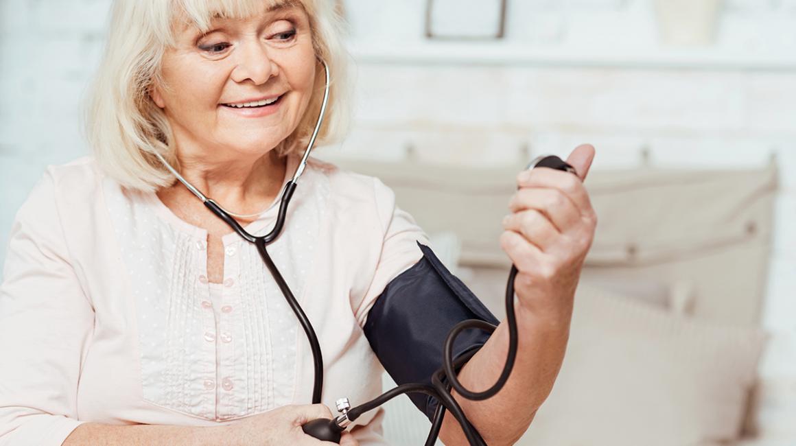 Starsza pani zadowolona z pomiaru ciśnienia