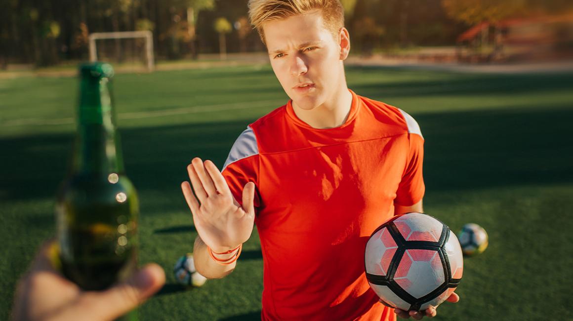 Młody piłkarz odmawia butelki z piwem