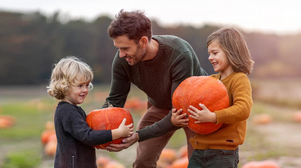 ojciec daje dzieciom dynie