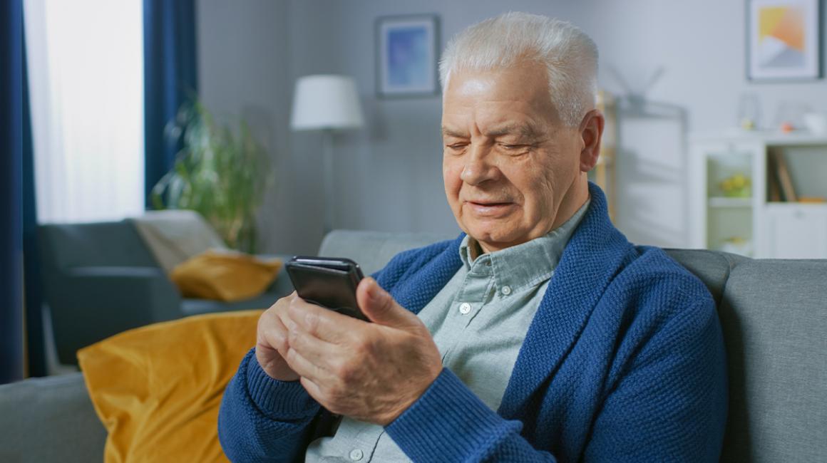 starszy pan patrzy na telefon