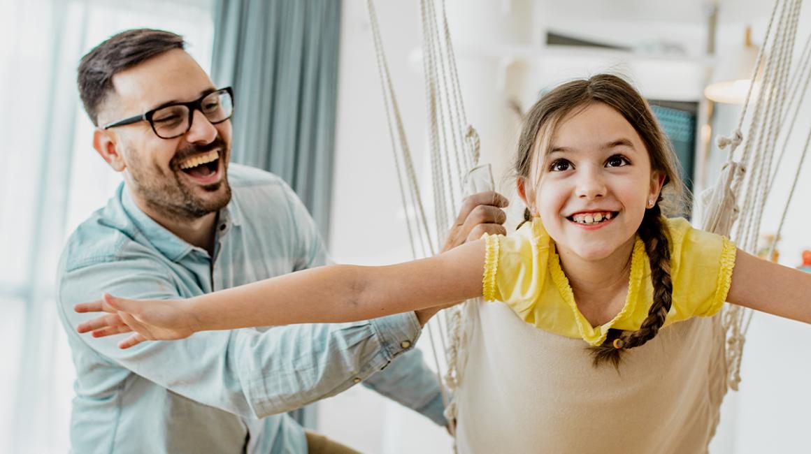 ojciec huśta dziewczynkę 