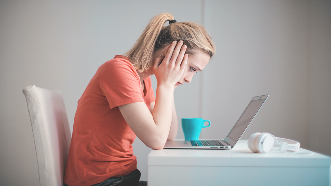 Przygnębiona kobieta przed laptopem