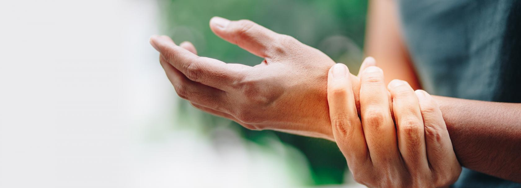 Kobieta trzyma się za nadgarstek