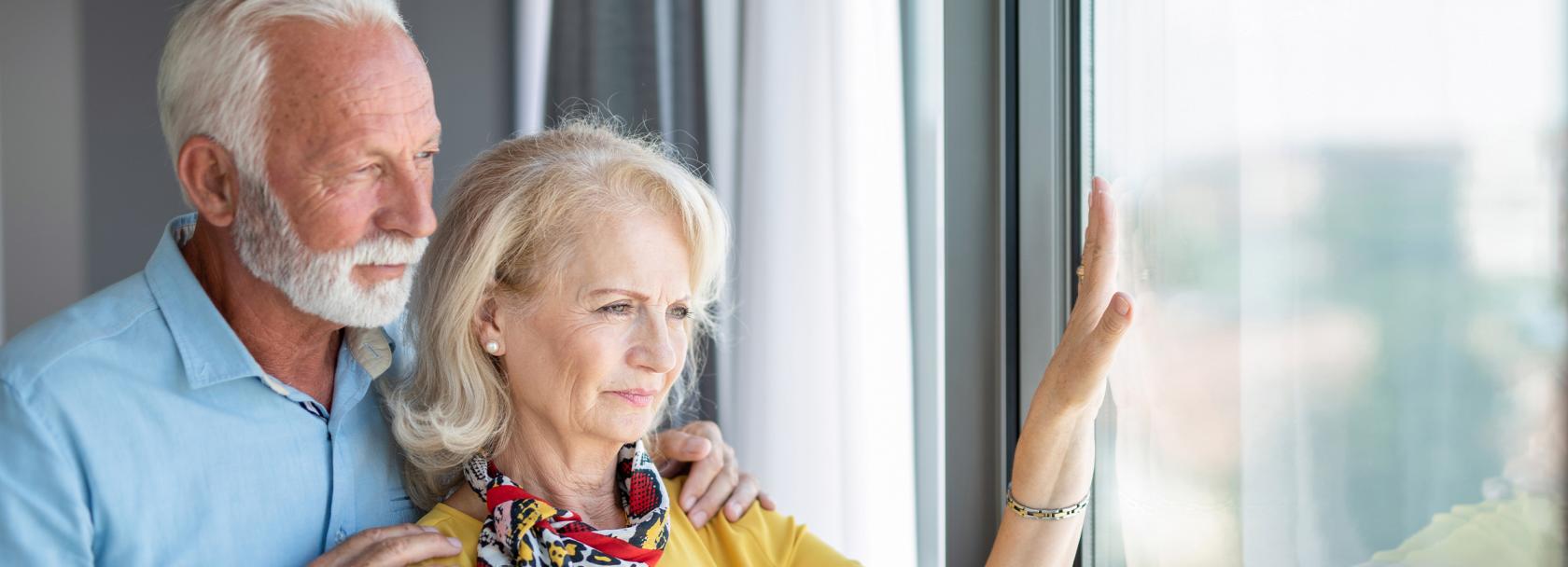 Starsze małżeństwo patrzy przez okno