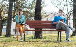 Para w maseczkach na dwóch krańcach ławki