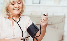 Starsza pani zadowolona z pomiaru ciśnienia