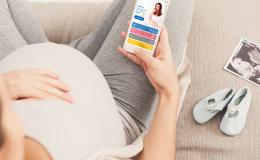 Kobieta w ciąży ogląda aplikację z dietą na komórce