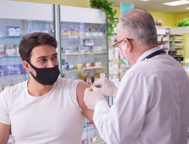 młody mężczyzna jest szczepiony przez farmaceutę
