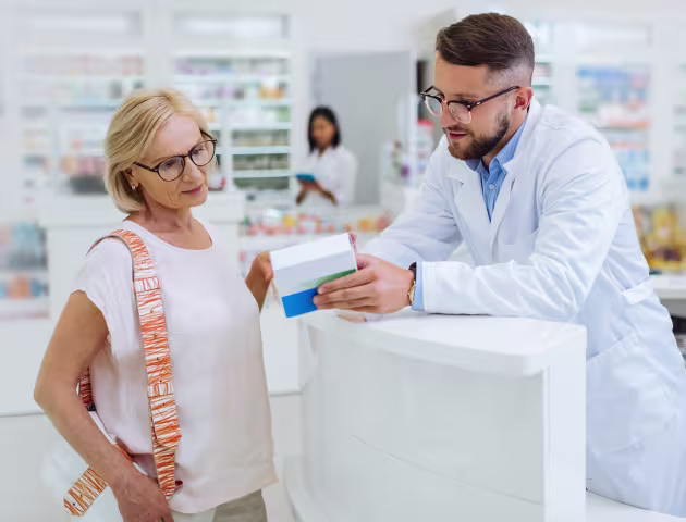 farmaceuta tlumaczy coś klientce, pani w srednim wieku w t-shircie