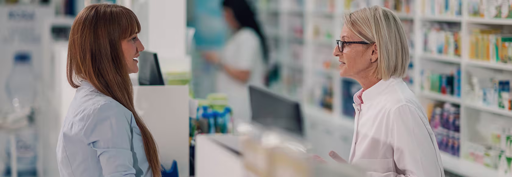 Kobieta rozmawia w aptece z farmaceutka
